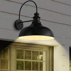 an outdoor light on the side of a house in front of a window and door