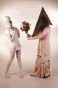 two people dressed up as zombies and holding flowers in front of each other's face