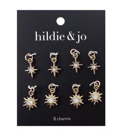 six pairs of gold tone earrings with white stones and stars on the front, in different shapes