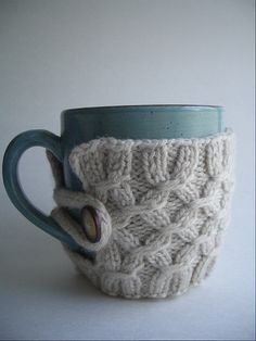 a knitted coffee cup cozys up with yarn