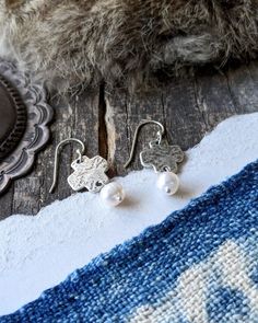 Inspired by the wild mountain tops. Where the most rugged rocks collide with the soft white clouds, creating a breathtaking view that only a few will ever see. We designed these easy to wear earrings to go with everything so that you can show your confident and feminine style all day, every day. Materials: sterling silver, ancient bronze, freshwater pearls (ear wires are sterling silver) Length: 1 1/4 inches White Hammered Sterling Silver Earrings, White Clouds, Cross Earrings, Mountain Top, Pearl Drop, Soft White, Breathtaking Views, Feminine Style, Ear Wires