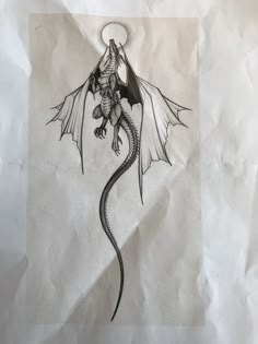 a drawing of a dragon sitting on top of a piece of paper