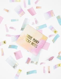 some pink and blue sticky notes on top of a white table with confetti