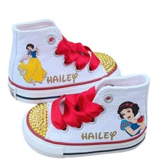 a pair of white shoes with snow princess on the side and red bows at the bottom