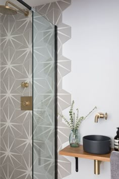 a bathroom with a glass shower door and wooden shelf