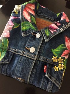 a jean jacket with flowers painted on it