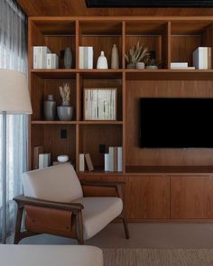 a living room filled with furniture and a flat screen tv mounted on a wooden wall