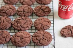 chocolate cookies cooling on a rack next to a can of coca - cola