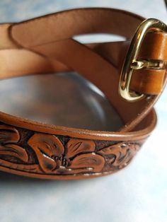 This belt is hand tooled using top grade vegetable tanned cowhide. The belt is 1-1/4" wide, hand dyed and stained the color of your choice. It has been finished using a multi- step process to insure many years of service. Colors may vary slightly due to the natural properties the leather. The back of the belts are also finished for extra protection and the edges are hand rubbed to a smooth finish so your belt won't wear out the belt loops on your pants. Buckles attach with snaps for easy removal Tan Cowhide, Western Belt, Western Belts, Brass Buckle, Hand Tools, Hand Dyeing, Solid Brass, Leather Bracelet, Belts