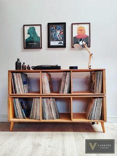 an old record player is sitting in front of two pictures on the wall above it