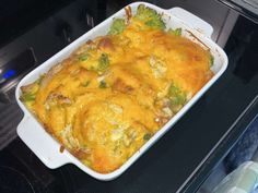 a casserole dish with broccoli and cheese in it on the stove