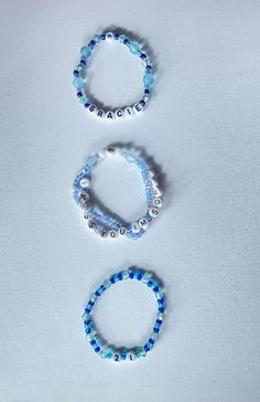 three bracelets with blue beads on white background