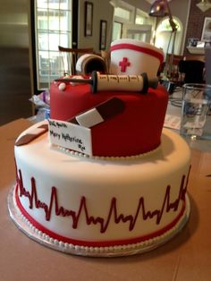 a red and white cake with medical items on it's top, sitting on a table