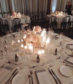 the table is set with candles, plates and silverware for an elegant wedding reception