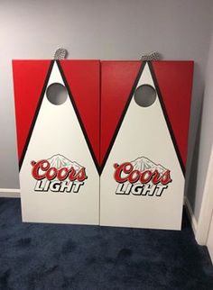 two coca cola light cornhole game boards in the corner of a room with carpet