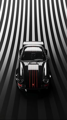 a black and white car with red stripes on it's hood is parked in front of a striped wall