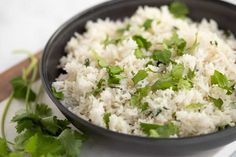 white rice and cilantro in a black bowl