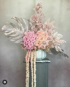 a vase filled with pink flowers and greenery