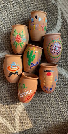 a group of clay pots sitting on top of a carpet