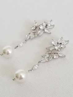 "Gorgeous sparkly cubic zirconia wedding earrings for the bride. Handcrafted with Swarovski pearls and high quality cubic zirconias. For pierced ears only. I do have other types of pearls available such as freshwater pearls and shell pearls that are in different shapes & sizes. Please contact for other options. ♥ SIZE: 2 1/8\" long x 3/4\" wide ♥ COLORS: Silver, Gold, Rose Gold ♥ PRODUCTION TIME: Ready to ship out in 1-2 business days ♥ IMPORTANT: Please be sure to read my policy section for Pearl-embellished Cubic Zirconia Drop Earrings, Cubic Zirconia Drop Earrings With Sparkling Stones, Pearl Embellished Cubic Zirconia Wedding Earrings, Diamond White Cubic Zirconia Pearl Earrings For Wedding, Pearl White Bridal Earrings With Pearl Drop, Silver Pearl Diamond Earrings For Wedding, Silver Pearl Earrings For Mother Of The Bride, Wedding Pearl Earrings With Sparkling Cubic Zirconia, Cubic Zirconia Pearl Drop Earrings