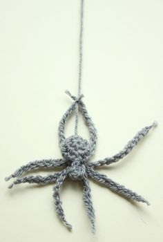 an ornament made out of yarn is hanging on a string and it looks like a spider