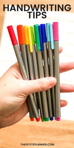 a hand holding several different colored pens in front of a piece of paper with the words handwriting tips written on it