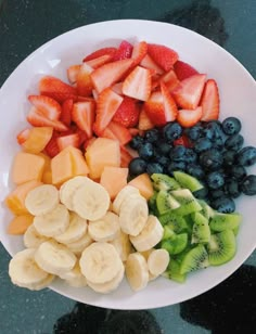 a white plate topped with sliced fruit and kiwis