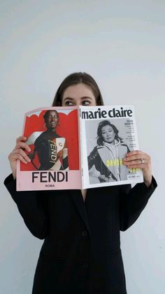 a woman holding two magazines in front of her face