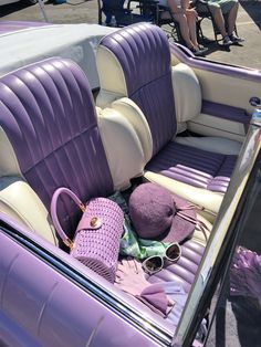 the interior of a purple and white car with sunglasses on it's headrests