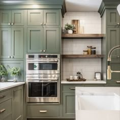 a kitchen with green cabinets and white counter tops, an open shelving above the stove