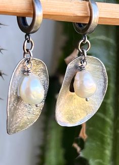 "Made with 925 silver sheet, molten to create an unique raw texture, then brush polished to a satin, brushed finish. Total drop is 1 3/4\". 3/4\" wide. The hoops are about 3/8\" diameter, or 10 mm . The light off white pearls have beautiful luster.  These 2 were salvaged a while ago from some other jewelry and I do not have that exact color anymore.  Will be shipped in a craft gift box." Silver Hand Cast Dangle Earrings, Hand Cast Silver Dangle Earrings, Silver Hand Cast Drop Earrings, Hand Cast Silver Drop Earrings, Elegant Hand Cast Drop Earrings, Elegant Hand Cast Metal Earrings, Artisan Silver Jewelry With Pearl Drop, Elegant Hand Cast Antique Silver Jewelry, Elegant White Oxidized Finish Earrings