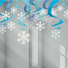 snowflakes and streamers are hanging from the ceiling in front of a window