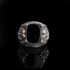 a silver ring sitting on top of a black surface