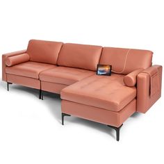 an orange leather sectional sofa sitting on top of a white floor