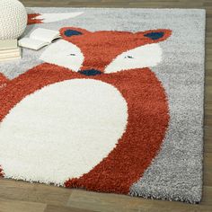 a red and white rug with a fox design on the floor in a living room