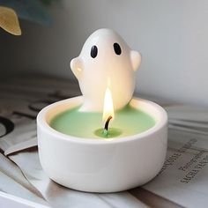 a white candle with a ghost face on it