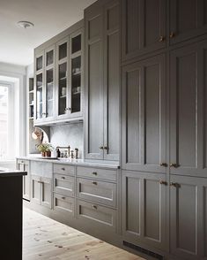 a kitchen with wooden floors and gray cabinets