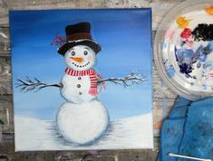 a painting of a snowman next to a bowl of paint