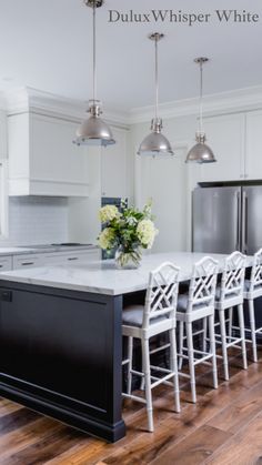 a kitchen with white cabinets and black island