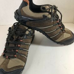 a pair of hiking shoes sitting on top of a white floor next to each other