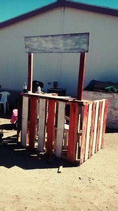 a small building made out of pallets and wooden slats in the middle of nowhere