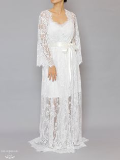 Floor length bridal lace robe with Chantilly French lace Length: 160 cm / 62 in Loose-fitting Bell sleeves Silky ribbon belt Scalloped neckline, lace cuffs and hemline Model is 160 cm/ 5'3'' and wearing a size S Luxury Long Sleeve Lace Dress With Lace Cuffs, Luxury Long Romantic Robe, Luxury Long Sleeve Feminine Robe, Luxury Long-sleeve Lace Dress With Lace Cuffs, Luxury Romantic Dress With Lace Cuffs, Luxury Fitted Lace Dress With Lace Cuffs, Luxury Romantic Lace Dress With Lace Cuffs, Delicate Lace Gown For Ceremonies, Ceremony Gown With Delicate Lace