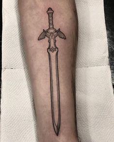 A sword tattoo is one of the most iconic designs. But only a few people know the true meaning behind it. Dive into our research to become a real sword tattoo lord. Zelda Breath Of The Wild Tattoo Ideas, Legend Of Zelda Breath Of The Wild Tattoo, Mastersword Zelda Tattoo, Legends Of Zelda Tattoo, Legend Of Zelda Tattoo Ideas, Breath Of The Wild Tattoo, Zelda Tattoo Ideas, Legend Of Zelda Tattoo, Zelda Tattoo