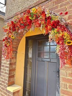 the front door is decorated with red and yellow flowers