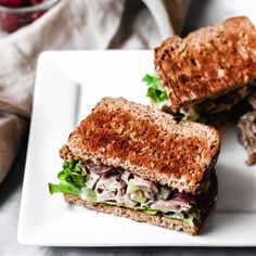 two halves of a sandwich sitting on top of a white plate