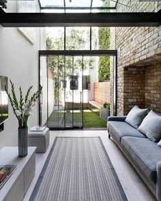 a living room with couches and a rug in front of a glass door that leads to an outdoor patio