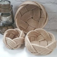 three rope baskets sitting on top of a white table