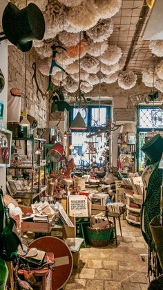 a room filled with lots of different types of furniture and decorations hanging from the ceiling