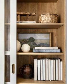 a bookshelf filled with lots of books next to a white door