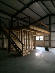 an empty warehouse with stairs and windows